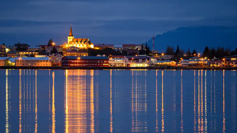 The town of Borgarnes reflected on still water at dusk in Iceland
