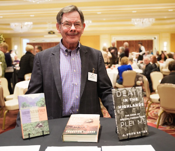 an osher instructor proudly displaying his teaching materials