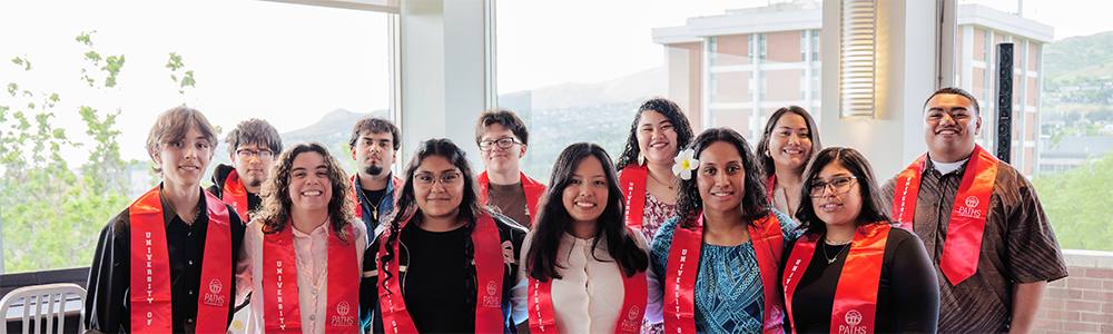 Two dozen students in graduation regalia.