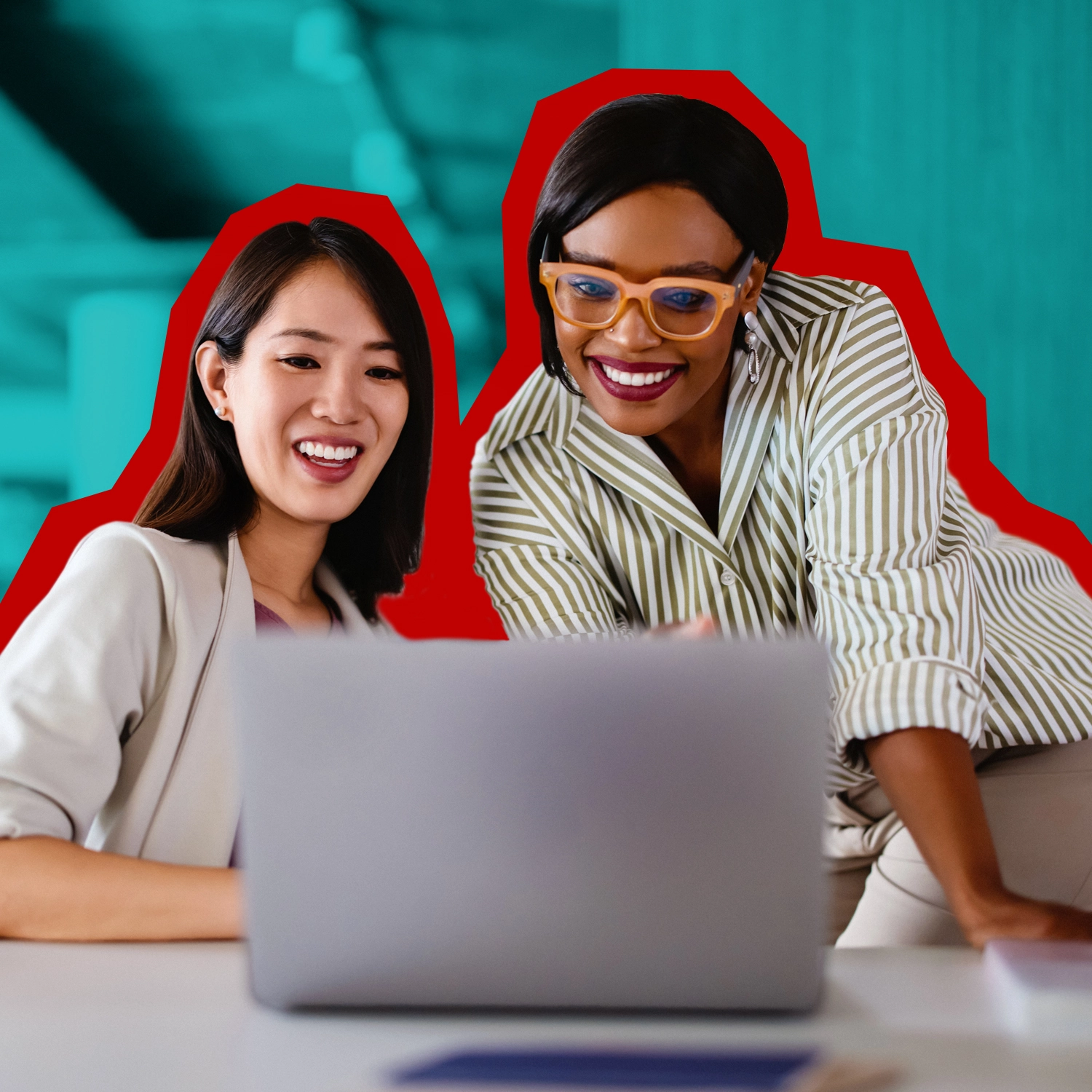 Two women looking at and smiling at a laptop.
