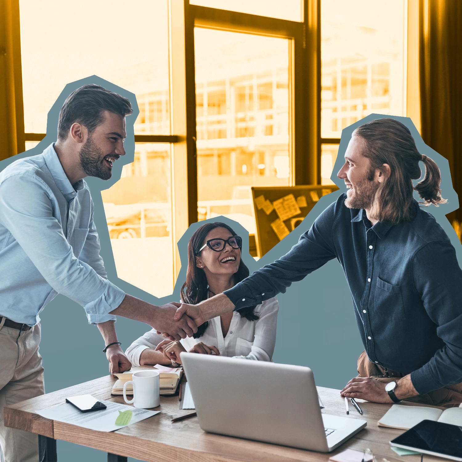 A man and a woman greet a newcomer at a desk.