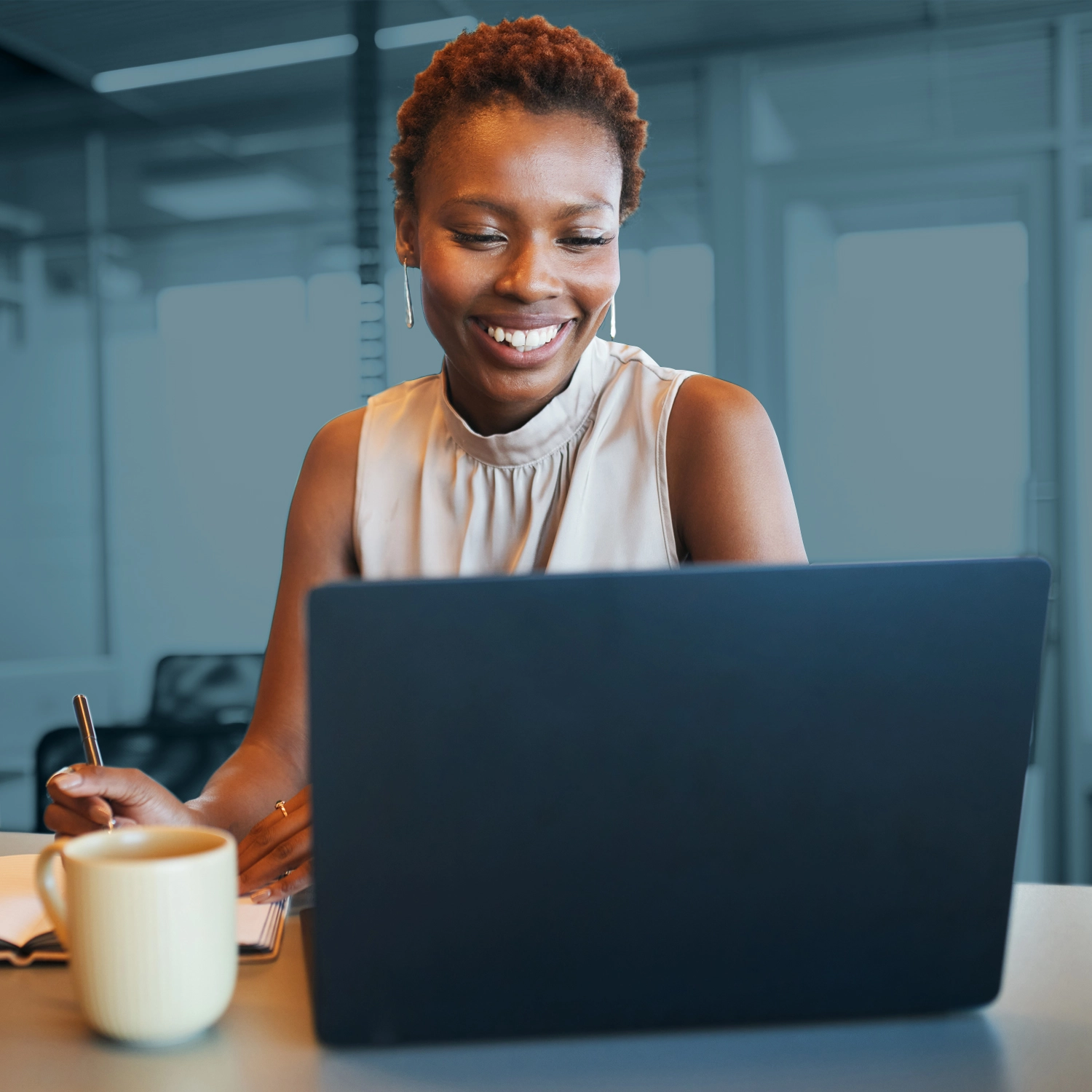 a woman smiling at a laptop.