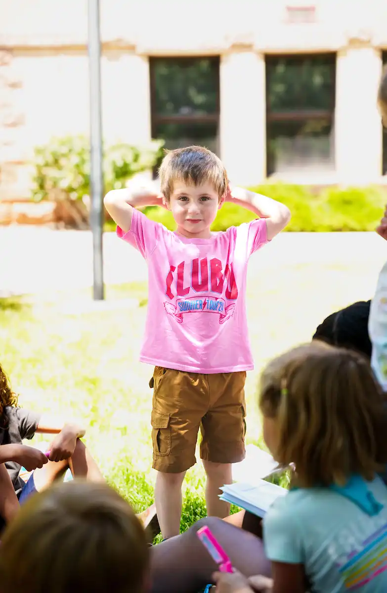 A Club U camper in a pink t shirt engaging in activities